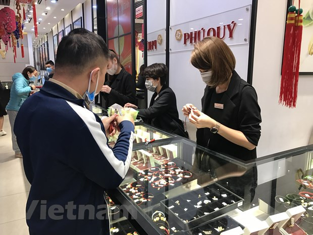 Khách hàng giao dịch vàng tại thị trường Hà Nội. (Ảnh: Đức Duy/Vietnam+) Tâm lý lạc quan trên thị trường vàng trong nước vẫn mạnh mẽ ảnh 1