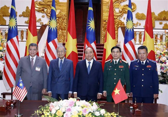 Thủ tướng Nguyễn Xuân Phúc và Thủ tướng Malaysia Mahathir Mohamad chứng kiến Lễ ký Ý định thư về Biên bản ghi nhớ giữa Chính phủ nước CHXHCN Việt Nam và Chính phủ Malaysia về hợp tác thực thi pháp luật và tìm kiếm cứu nạn trên biển. (Ảnh: Thống Nhất/TTXVN) Toàn văn Tuyên bố chung giữa hai nước Việt Nam và Malaysia ảnh 2