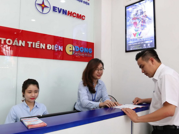Đoàn thanh niên EVN HCMC hướng dẫn khách hàng thanh toán tiền điện không dùng tiền mặt và các dịch vụ về điện. (Ảnh: Thanh Vũ/TTXVN) TP.HCM đảm bảo cung cấp điện liên tục cho kỳ thi THPT Quốc gia 2017 ảnh 1