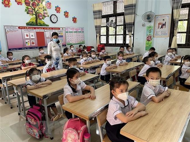 Học sinh lớp 1 Trường Tiểu học Hàm Nghi (thành phố Đông Hà, tỉnh Quảng Trị) đi học trực tiếp trở lại. (Ảnh: Thanh Thủy/TTXVN) Học sinh trở lại trường: Thời gian kiểm tra giữa kỳ có thể điều chỉnh ảnh 1
