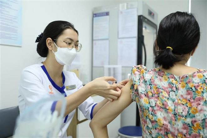 Khách đến tiêm tại điểm tiêm chủng của VNVC Trường Chinh (Hà Nội). (Ảnh: Minh Quyết/TTXVN) Ngày 26/3: Ghi nhận 7 ca mắc mới COVID-19, không ca tử vong ảnh 1