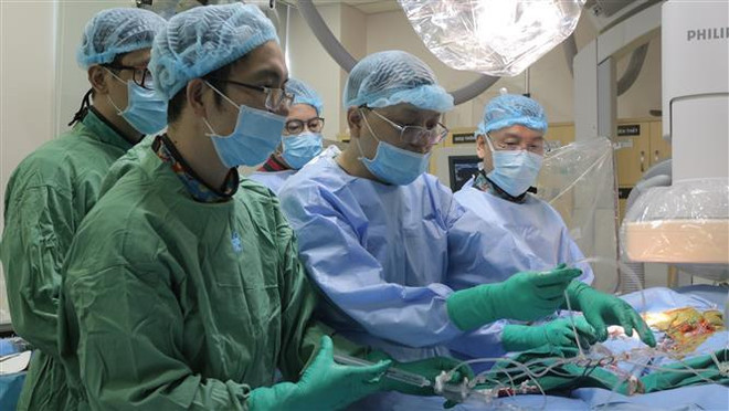 Các bác sỹ Bệnh viện Đại học Y dược Thành phố Hồ Chí Minh thực hiện thay van động mạch chủ qua da cho bệnh nhân. (Ảnh: TTXVN phát) Việt Nam đã làm chủ kỹ thuật thay van động mạch chủ qua da ảnh 1
