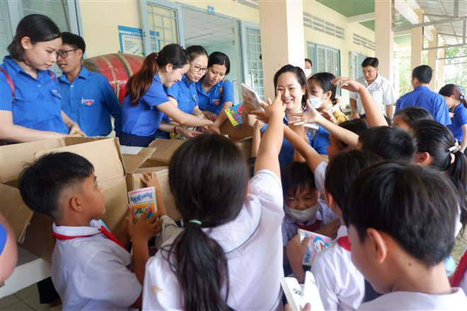 Học sinh trường Trường tiểu học Nhơn Hòa hào hứng được nhận sách mới. (Ảnh: Đức Hạnh/TTXVN) Trao tặng Tủ sách Đinh Hữu Dư đầu tiên tại khu vực phía Nam ảnh 2