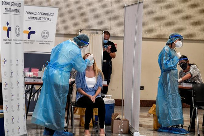 Nhân viên y tế lấy mẫu dịch COVID-19 cho người dân tại Athens, Hy Lạp. (Ảnh: AFP/TTXVN) Thế giới đã ghi nhận gần 41,5 triệu ca nhiễm COVID-19 ảnh 2