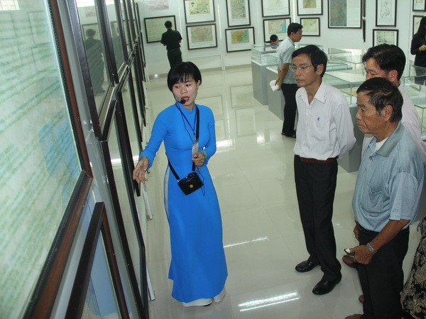 Du khách đến tham quan, tìm hiểu về các hiện vật, bản đồ trưng bày tại triển lãm. (Ảnh: Bùi Như Trường Giang/TTXVN) Trưng bày bản đồ, tư liệu Hoàng Sa và Trường Sa tại Long An ảnh 1