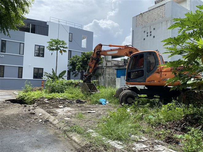 Huy động máy móc, nhân lực xử lý các hố sụt và người dân trong khu vực nguy cơ được yêu cầu di dời để đảm bảo an toàn. (Ảnh: TTXVN phát) ttxvn_2406_ho tu than (2).jpg