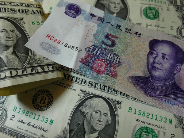 Đồng USD (trái) và nhân dân tệ (phải). (Nguồn: AFP/TTXVN) Lượng bán ròng ngoại hối của các ngân hàng Trung Quốc tiếp tục tăng ảnh 1