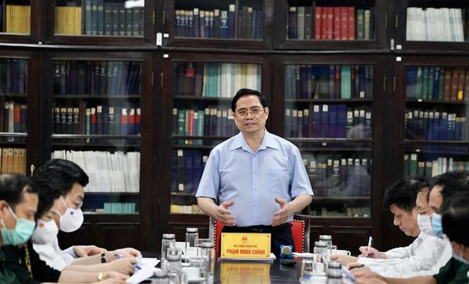 Thủ tướng Phạm Minh Chính đến thăm và làm việc với lãnh đạo Viện Vệ sinh Dịch tễ Trung ương. (Ảnh: Dương Giang/TTXVN) Thủ tướng: Chậm nhất tháng 6/2022 phải có vaccine sản xuất trong nước ảnh 1