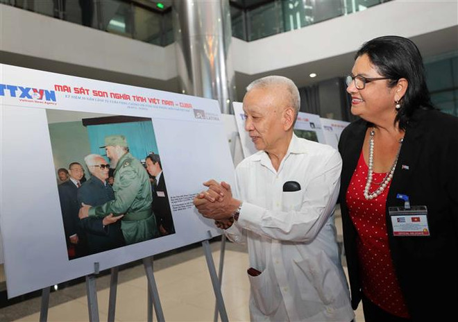 Nhân chứng trong bức ảnh tại trưng bày vui mừng kể về kỷ niệm với Lãnh tụ Cuba Fidel Castro. (Ảnh: Thanh Tùng/TTXVN) Trưng bày ảnh quý về Lãnh tụ Fidel và nghĩa tình Việt Nam-Cuba ảnh 2