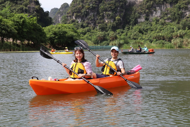 Du khách trải nghiệm chèo thuyền kayak. (Ảnh: Đức Phương/TTXVN) Về Khu du lịch sinh thái Tràng An trải nghiệm chèo thuyền kayak ảnh 1