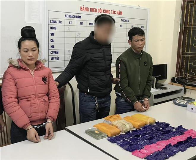 Hai đối tượng và tang vật tại cơ quan Công an. (Ảnh: TTXVN phát) Sơn La phá chuyên án lớn, thu giữ hơn 32.000 viên ma túy tổng hợp ảnh 1