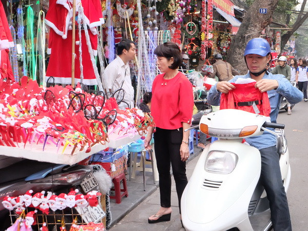 Người dân mua sắm quà Noel tại phố Hàng Mã, Hà Nội. (Ảnh: Đỗ Phương Anh/TTXVN) Hà Nội rộn ràng cùng không khí đón Giáng sinh và tết Dương lịch ảnh 1