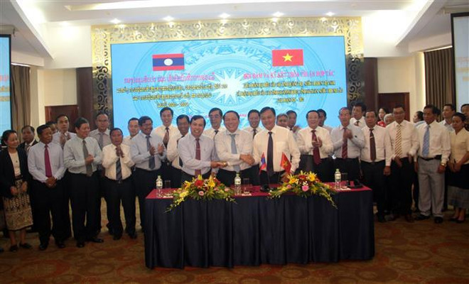Trưởng đoàn đại biểu ba tỉnh Quảng Trị, Savannakhet, Salavan bắt tay đoàn kết, hữu nghị sau khi ký kết văn bản thỏa thuận hợp tác. (Ảnh: Trịnh Bang Nhiệm/TTXVN) Hợp tác phát triển giữa ba tỉnh Quảng Trị-Savannakhet-Salavan ảnh 1