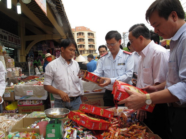 Đoàn Thanh tra Bộ Y tế và thanh tra liên ngành Thành phố Hồ Chí Minh kiểm tra bánh mứt Tết tại chợ Bình Tây. (Ảnh: Phương Vy/TTXVN) An toàn thực phẩm dịp Tết và mùa lễ hội 2017: Kiểm thanh tra liên tục ảnh 1