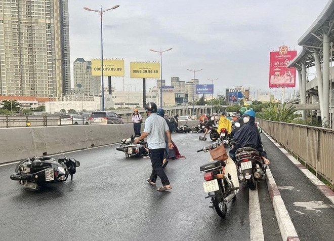 Đường trơn trợt vì mưa khiến nhiều người dân té ngã tại khu vực Cầu Sài Gòn. (Ảnh: Hồng Giang/TTXVN) ttxvn_0505_mua lon (3).jpeg