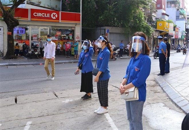 Lực lượng thanh niên tình nguyện hỗ trợ thí sinh dự thi tốt nghiệp Trung học Phổ thông năm 2021, tại điểm thi Trường Trung học Phổ thông Thăng Long, quận Hai Bà Trưng, Hà Nội. (Ảnh: Hoàng Hiếu/TTXVN) Tiếp sức mùa thi 2022: Nhiều hoạt động, giải pháp mới hỗ trợ thí sinh ảnh 1