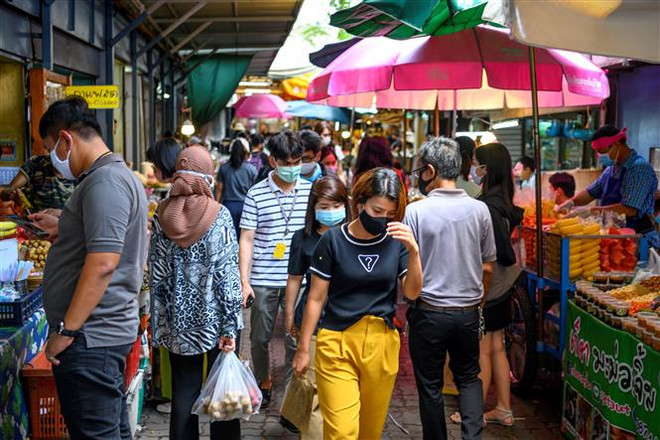 Người dân đeo khẩu trang phòng lây nhiễm COVID-19 tại Bangkok, Thái Lan. (Ảnh: AFP/TTXVN) Thủ tướng Thái Lan phát động cách làm việc ''bình thường mới'' ảnh 1