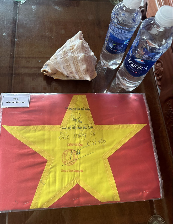 Những kỷ vật quý báu, trong đó có chai nước biển lấy tại vùng biển Trường Sa của chị Trần Thị Liên mang về sau chuyến công tác tại Trường Sa. (Ảnh: TTXVN phát) ttxvn_truong sa.jpg