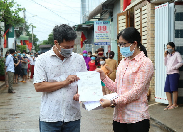 Chính quyền địa phương trao giấy hoàn thành thời gian cách ly phong tỏa cho người dân. (Ảnh: Tuấn Anh/TTXVN) Đắk Lắk: Gỡ bỏ phong tỏa khu dân cư có bệnh nhân mắc COVID-19 ảnh 2