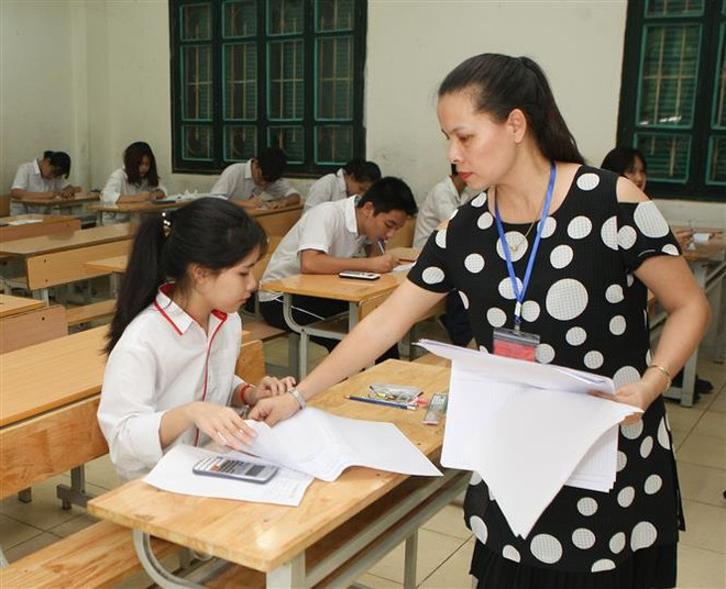 Giám thị phát giấy thi cho thí sinh thi môn Toán. (Ảnh: Thanh Tùng/TTXVN) Tuyển sinh vào lớp 10: Hà Nội sẽ công bố môn thi thứ tư vào tháng 3 ảnh 2