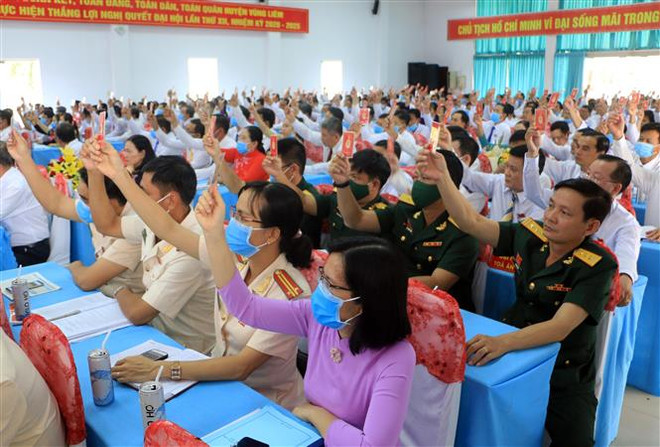 Các đại biểu biểu quyết thông qua Nghị quyết Đại hội Đảng bộ huyện Vũng Liêm, Vĩnh Long. (Ảnh: Phạm Minh Tuấn/TTXVN) Nhìn lại đại hội đảng bộ cấp trên cơ sở: Kinh nghiệm từ thực tiễn ảnh 1