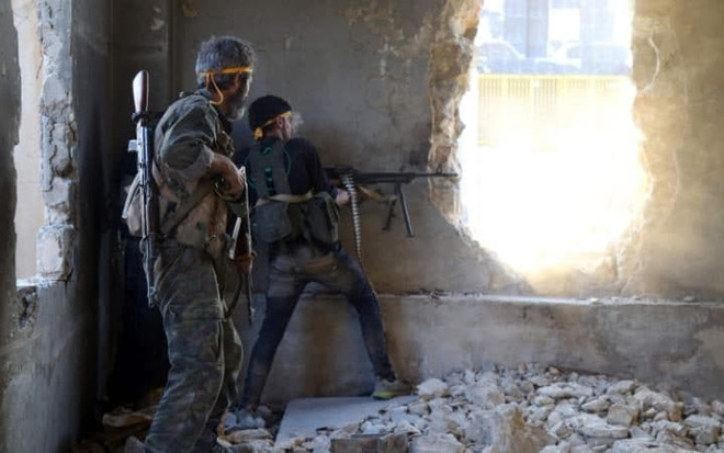 Phiến quân nổ súng vào quân chính quyền Syria ở Aleppo. (Nguồn: Telegraph) Quân đội Syria bắn pháo dồn dập vào vị trí của phiến quân ở Aleppo ảnh 1