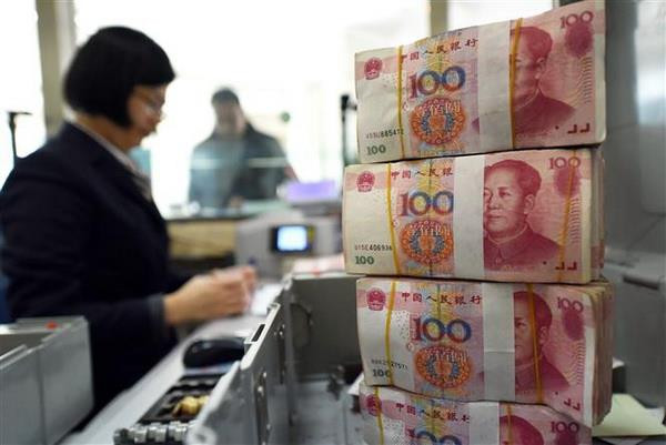 Kiểm đồng 100 Nhân dân tệ tại ngân hàng ở tỉnh Giang Tô. (Nguồn: AFP/TTXVN) Ngân hàng trung ương Trung Quốc ''bơm'' tiền vào thị trường ảnh 1