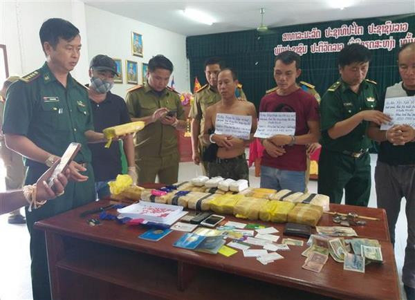 Các đối tượng và tang vật bị bắt giữ tại cơ quan điều tra. (Ảnh: Thanh Thủy/TTXVN) Bắt giữ 3 đối tượng vận chuyển 100.000 viên ma túy từ Lào về Việt Nam ảnh 1