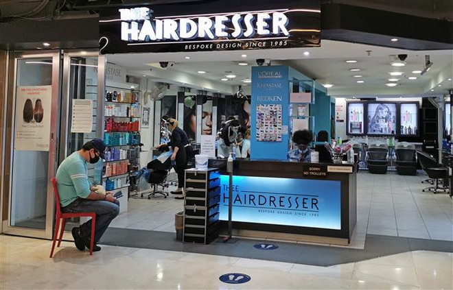 Người dân đeo khẩu trang phòng lây nhiễm COVID-19 tại một tiệm cắt tóc ở Johannesburg, Nam Phi. (Ảnh: THX/TTXVN) WHO ghi nhận số ca mắc mới COVID-19 cao kỷ lục trong ngày ảnh 2