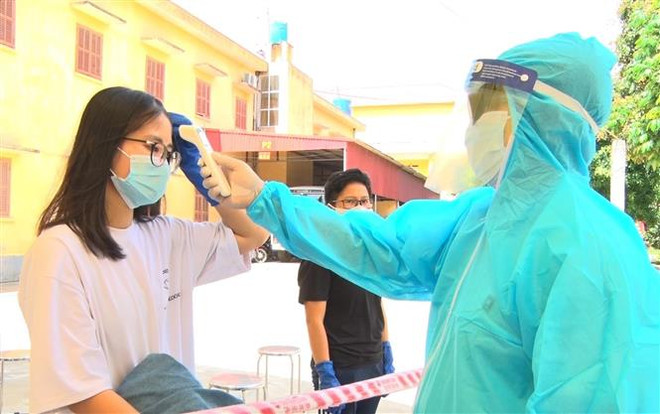 Kiểm tra thân nhiệt lần cuối cho người hoàn thành cách ly. (Ảnh: Đinh Tuấn/TTXVN) 88 ngày Việt Nam không có ca lây nhiễm COVID-19 trong cộng đồng ảnh 1