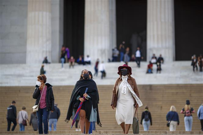Người dân đeo khẩu trang phòng lây nhiễm COVID-19 tại Washington, D.C., Mỹ. (Ảnh: THX/TTXVN) Một loạt bang của Mỹ công bố các biện pháp hạn chế mới ảnh 1