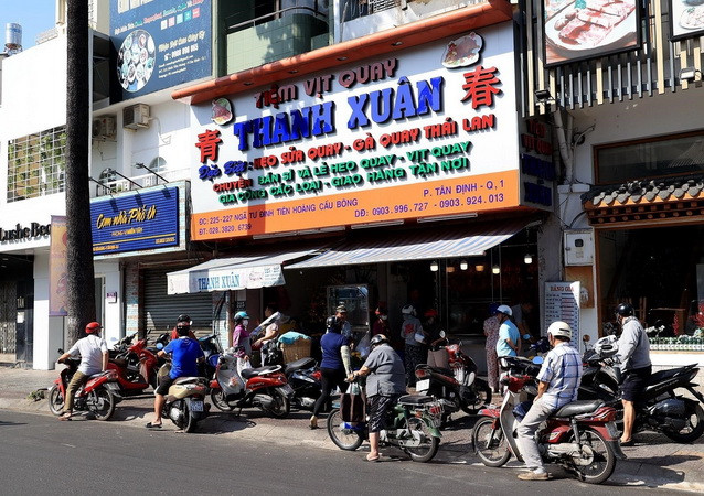 Một tiệm vịt quay trên đường Đinh Tiên Hoàng (phường Tân Định, quận 1) khá đông người đứng chờ mua hàng. (Ảnh: Hồng Đạt/TTXVN) TP.HCM: Kênh bán lẻ đóng cửa, cửa hàng tiện lợi phục vụ xuyên Tết ảnh 2