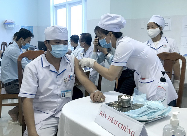 Tiêm vaccine phòng COVID-19 cho nhân viên y tế làm công tác phòng, chống dịch tại Bệnh viện Đa khoa tỉnh Vĩnh Long. (Ảnh: Lê Thúy Hằng/TTXVN) Vĩnh Long, Nghệ An triển khai tiêm vaccine phòng COVID-19 đợt 1 ảnh 1