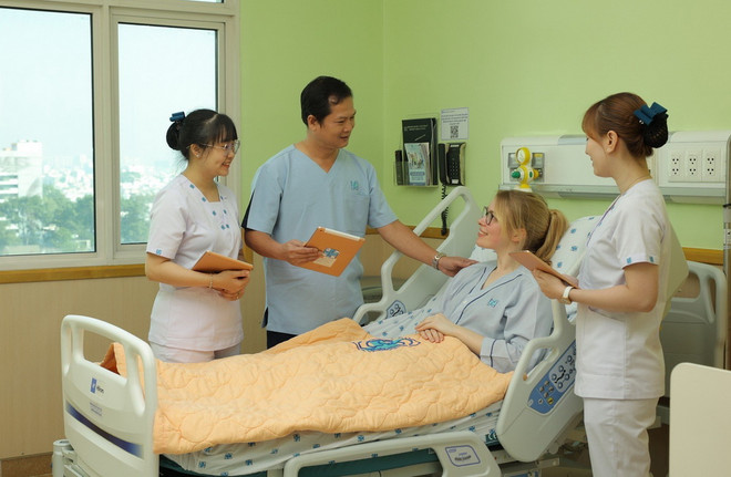 Nhân viên y tế Bệnh viện Đại học Y dược Thành phố Hồ Chí Minh sử dụng máy tính bảng cập nhật và chia sẻ thông tin với người bệnh. (Ảnh: TTXVN phát) ttxvn_y te TPHCM3.jpg
