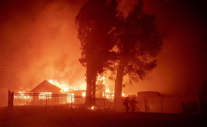 Lửa cháy rừng bốc ngùn ngụt thiêu rụi nhiều ngôi nhà tại North Park, khu vực lân cận San Bernardino, bang California (Mỹ). (Ảnh: AFP/TTXVN) 15 thảm họa thiên tai có mức thiệt hại từ 1 tỷ USD trở lên ảnh 1
