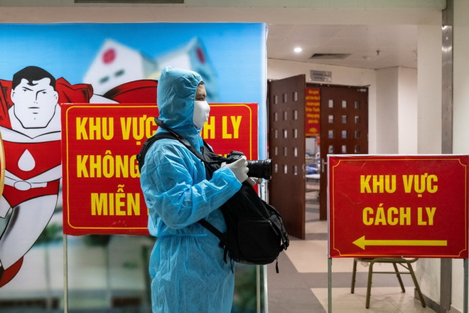 Phóng viên Minh Quyết, Ban Biên tập Ảnh TTXVN, tác nghiệp trong khu cách ly phòng COVID-19. (Ảnh: TTXVN) Những con người lặng lẽ trong tâm dịch: Quên mình vì trách nhiệm chung ảnh 1
