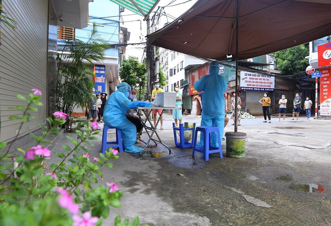 Lấy mẫu xét nghiệm tại Hà Nội. (Ảnh: TTXVN/Vietnam+) Thủ đô những ngày giãn cách: Căng sức qua chiến dịch gần 60 ngày đêm ảnh 2