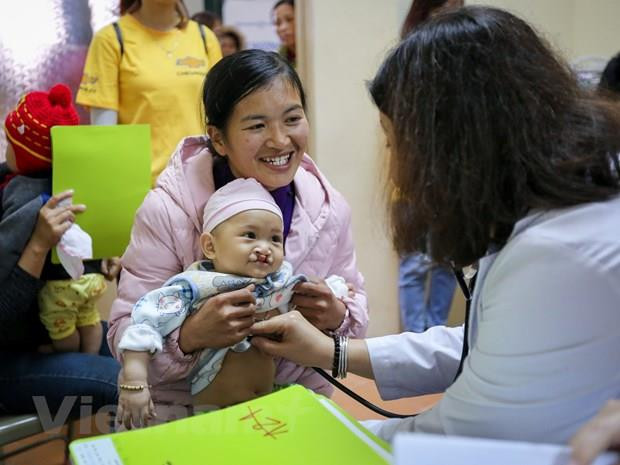 Khám cho một bệnh nhi bị dị tật khe hở môi. (Ảnh: Minh Sơn/Vietnam+) Phẫu thuật miễn phí dị tật khe hở vòm miệng cho trẻ em ảnh 1