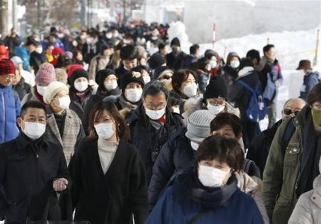 Du khách tại Lễ hội tuyết Sapporo, Nhật Bản. (Ảnh: Kyodo/TTXVN) Chính phủ Nhật hỗ trợ tài chính các doanh nghiệp sản xuất khẩu trang ảnh 1