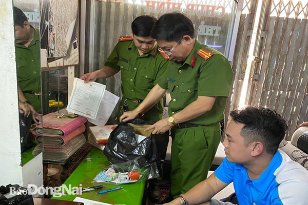 Công an kiểm tra thu các loại giấy tờ tại tiệm áo cưới của Linh. (Ảnh: Công an Đồng Nai) Bắt giữ đối tượng làm giả con dấu, tài liệu trong cửa hàng áo cưới ảnh 1
