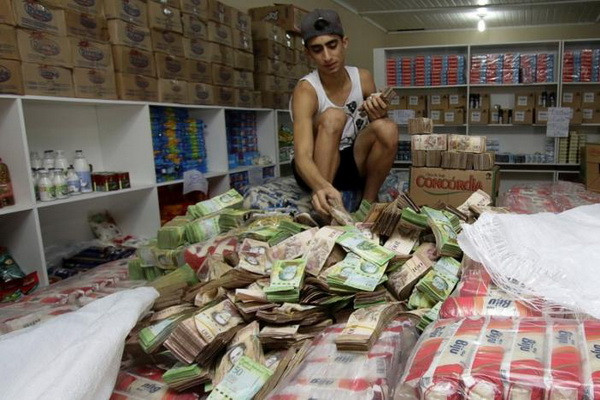 Một người đàn ông đếm những đồng tiền bolivar trong một cửa hàng ở Brazil. (Nguồn: Reuters) Ngăn nạn đưa lậu tiền vào trong nước, Venezuela đóng cửa biên giới ảnh 1