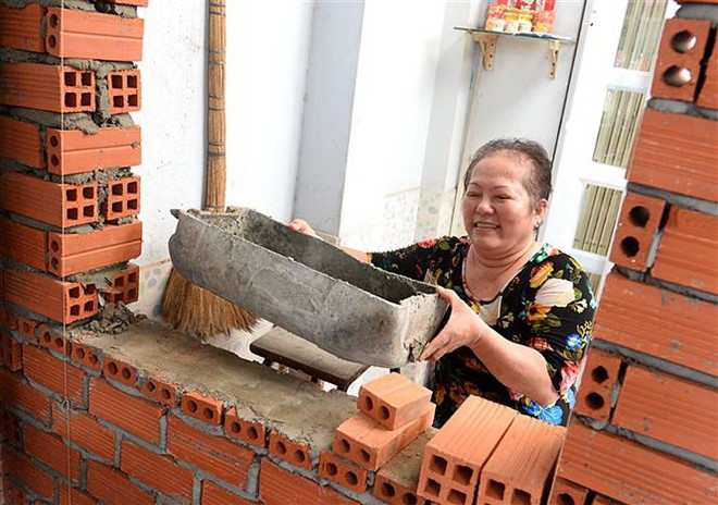 Người dân hẻm 62, Quận 3 vui vẻ, đồng lòng hiến đất mở rộng hẻm. (Ảnh: Thanh Vũ/TTXVN) Lan tỏa phong trào hiến đất mở rộng hẻm tại Thành phố Hồ Chí Minh ảnh 1