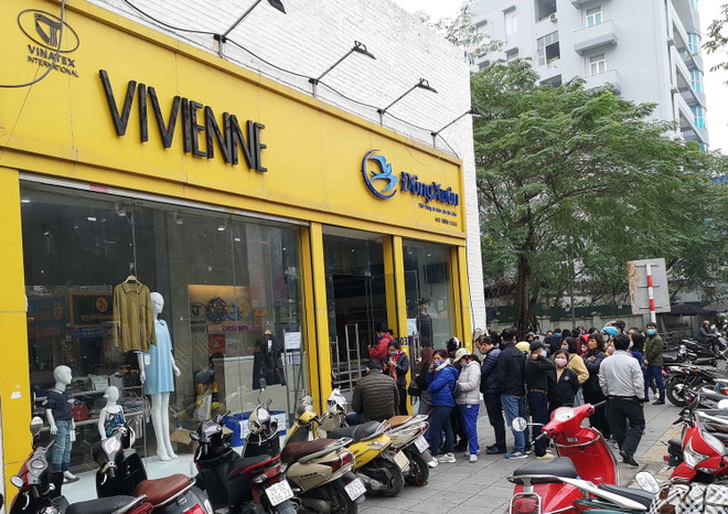 Người dân xếp hàng mua khẩu trang của Công ty Dệt kim Đông Xuân chiều 6/2 vừa qua. (Ảnh: Thanh Tùng/TTXVN) Doanh nghiệp dệt may tăng năng lực sản xuất khẩu trang phòng COVID-19 ảnh 1