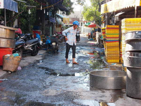 Nước thải từ các vựa hải sản trong khu vực chợ cá tạm Long Xyên xả thẳng ra đường Lương Thế Vinh, tạo thành những vũng nước đen. (Ảnh: Công Mạo/Vietnam+) An Giang: Dân kêu cứu vì chợ cá tạm xả thải ra môi trường ảnh 1