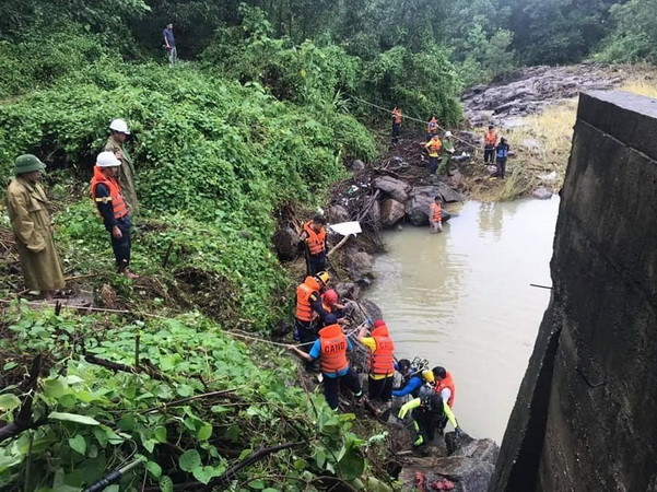 Lực lượng chức năng tiến hành trục vớt thi thể anh Thái Bá Thuận. (Ảnh: TTXVN phát) Đà Nẵng: Tìm thấy thi thể nạn nhân bị lũ cuốn ở huyện Hòa Vang ảnh 1