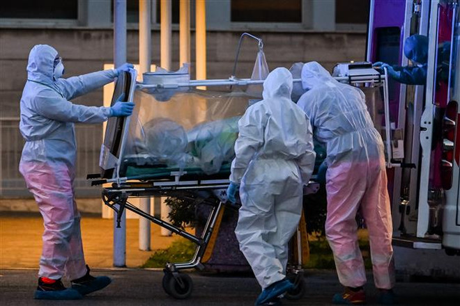 Nhân viên y tế chuyển bệnh nhân nhiễm COVID-19 tới bệnh viện ở Rome, Italy. (Ảnh: AFP/TTXVN) Sứ mệnh của Liên hợp quốc và 4 mục tiêu chưa thể hoàn thành ảnh 4