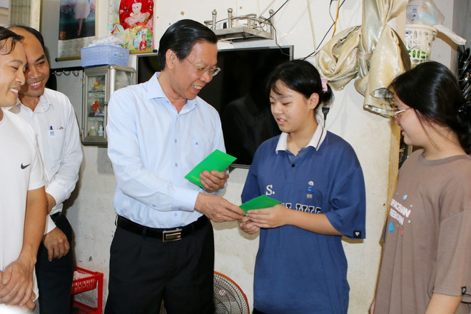 Chủ tịch UBND Thành phố Hồ Chí Minh Phan Văn Mãi lì xì Tết cho con em công nhân, người lao động tại nhà lưu trú công nhân Hiệp Phước. (Ảnh: Thanh Vũ/TTXVN) ttxvn_TPHCM1.jpg