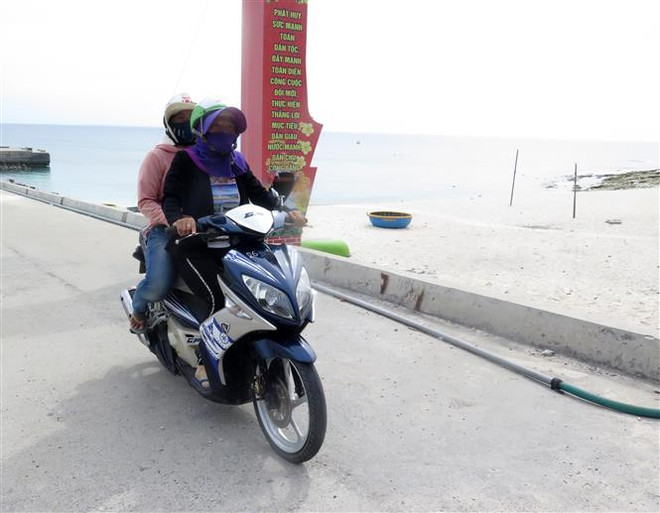 Chị em chạy xe ôm chở khách. (Ảnh: Lê Ngọc Phước/TTXVN) Tổ ''xe ôm đặc biệt'' của chị em phụ nữ ở đảo Lý Sơn ảnh 2
