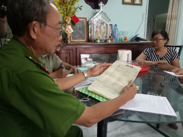 Cảnh sát khu vực hướng dẫn người dân kê khai thông tin cá nhân. (Ảnh: Thành Chung/TTXVN) TP.HCM bắt đầu triển khai thu thập dữ liệu quốc gia về dân cư ảnh 1