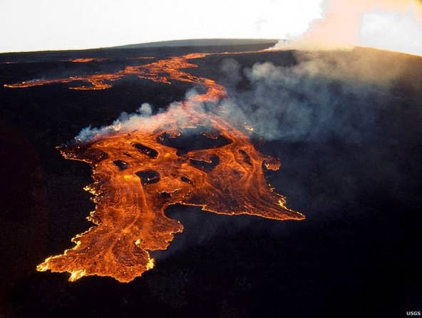 Dòng dung nham đỏ rực trào ra từ miệng núi lửa Mauna Loa. (Nguồn: AFP) Núi lửa lớn nhất thế giới phun trào sau 40 năm ngủ yên ảnh 1